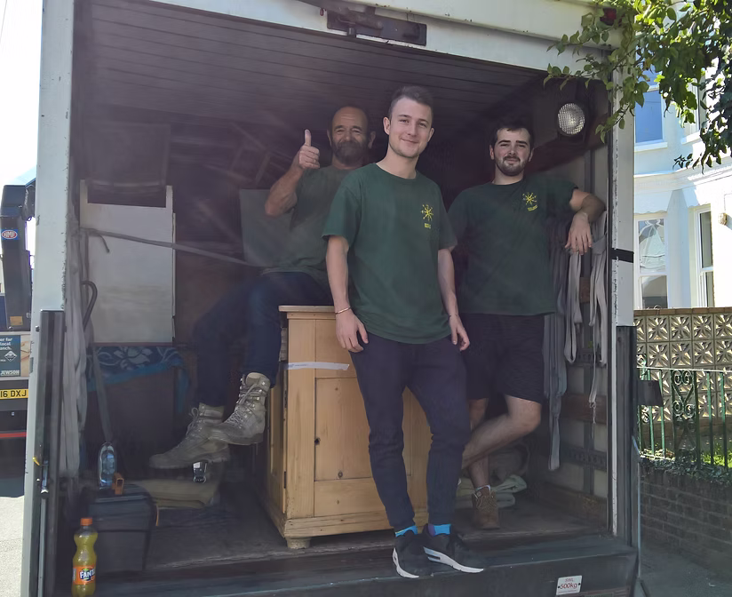 Father and son standing in front of a removals truck outside their warehouse